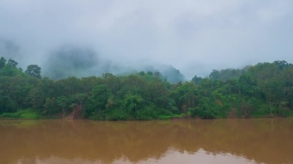 Wall Mural - Time lapse: cloud mist and fog over jungle Nam Ou River Nong Khiaw Muang Ngoi Laos, scenic mountain landscape, famous travel destination in South East Asia