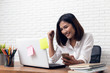 © suriya - Asian young Businesswoman working laptop computer on wood desk in Home office