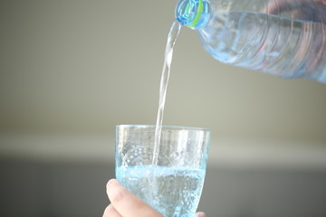 The water is poring into a blue stylish glass