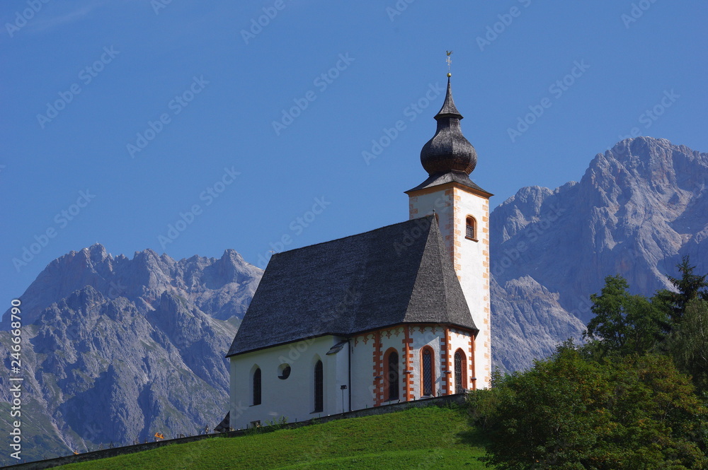 Kościółek na wzgórzu a Alpami w tle - obrazy, fototapety, plakaty 