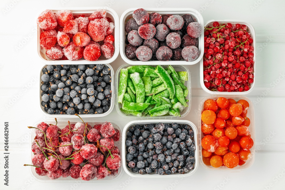 Top view frozen vegetables and berries in plastic containers - obrazy, fototapety, plakaty 