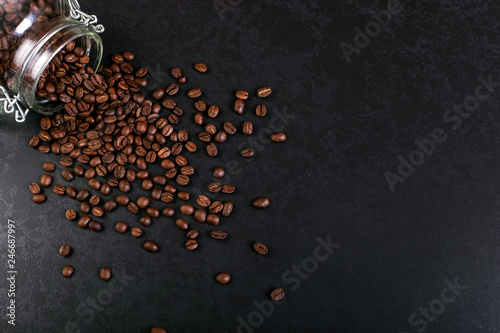 Fotomural Fragrant coffee beans are scattered from a jar on a rustic tabletop background