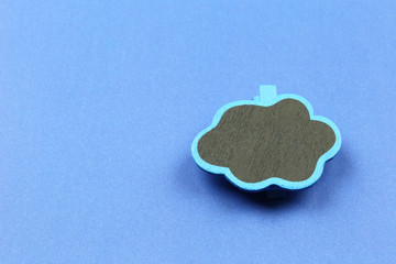 Wall Mural - wooden cloud shape on blue paper background.