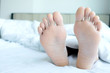 © Media  - Beautiful legs and feet She sleeps happily under a blanket in her bedroom at home.