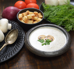 Champignon mushroom cream soup in bowl on wooden background. Rustic style. 