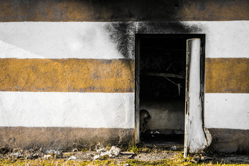 Wall Mural - A partially burnt buildin with striped wall. Stripes on a wall. Charred building.