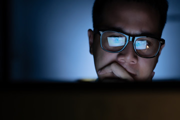 Focused and serious looking man working and thinking hard on computer