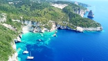 Aerial Drone Bird's Eye View Video Of Tropical White Rocky Bay Of Erimitis With Turquoise Clear Waters And Sail Boats Docked, Island Of Paxos, Ionian, Greece