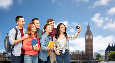 Sticker - education, high school and technology concept - group of smiling students with books taking selfie by smartphone over london city background