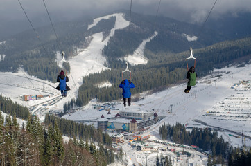 zip-line in the mountains winter three people