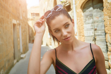 Canvas Print - attractive woman tourist with hat in old italian town