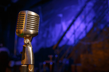 Retro microphone against dim blue light restaurant background