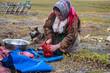 © evgenii - The extreme north, Yamal, the past of the Nenets people, the womens cuts the meat of the reindeer