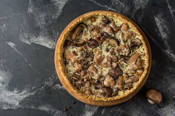 Mushroom Quiche Pie with champignons and cheese on dark background, top view. Savory tart with mushrooms. Galette. Tart with chicken. Chicken pie. Mushroom pie.