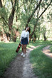 © soleg - young woman walking in the forest and playing guitar, summer nature, bright sunlight, shadows and green leaves, romantic feelings