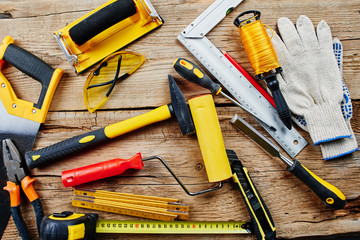 set of construction tools on a wooden background top view