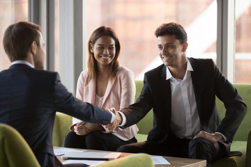 Wall Mural - Happy arabic businessman handshaking caucasian man in suit at multi-ethnic meeting, diverse partners shaking hands after signing contract making business deal, international collaboration concept