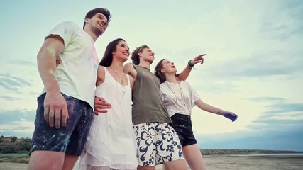 Sticker - View from below of Cheerful friends having rest while walking together on beach