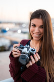 Fototapeta Paryż - Beautiful smiling woman holds a retro camera