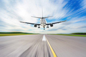 Wall Mural - Airliner landed on the runway at the airport, flying overhead at high speed.