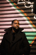 © Kristen Blush - African American man wearing all black in a colorful urban environment