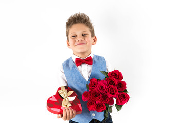 Saint Valentine's day. Pretty girl with red dress and gentleman boy with blue vest, red butterfly tie,  red roses bucket and heart shaped gift box. Valentines day kids. Love and friendship. Woman Day