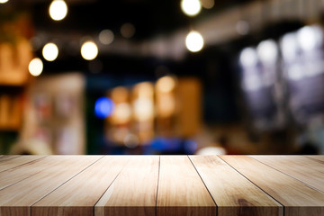 Wall Mural - Wooden table with blur background of coffee shop.