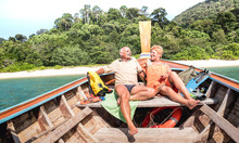 Senior Couple Vacationer Relaxing At Island Hopping Tour After Beach Exploration During Snorkel Boat Trip In Thailand - Active Elderly And Travel Concept On Tour Around World - Warm Day Bright Filter