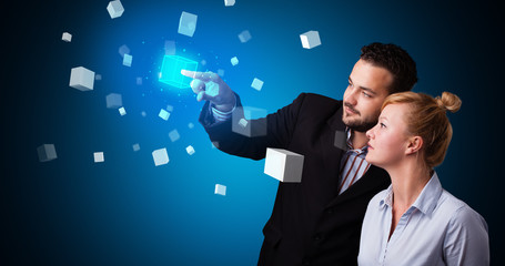 Poster - Man and woman touching hologram screen displaying cube symbols

