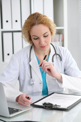 Wall Mural - Doctor woman at work. Physician filling up medical history records form at the desk. Medicine, healthcare  concept