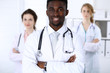 © rogerphoto - Happy african american doctor with medical staff at the hospital. Multi ethnic people group