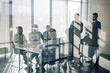 © alfa27 - Side view of blurred silhouettes of businessmen talking in conference room, view through the transparent glass wall