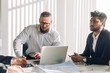 © alfa27 - Happy optimistic middle-aged athletic business owner leading his team. Confident successful businessman and his multiracial colleagues in background. Successful team concept