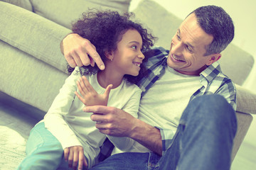 Eager smart girl getting interesting knowledge about the world from her dad.
