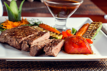 Wall Mural - Beef steak with grilled vegetables served on white plate. Food concept