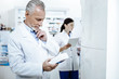 © Viacheslav Yakobchuk - Two drugstore workers in white coat looking busy