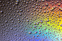 Drops Of Water On The Glass, With The Reflection Of The Rainbow.