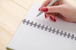 © Oleksandr - girl writes in a notebook, red nail polish