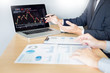 © snowing12 - Stock traders looking at finance analysis marketing report trading stocks online in office.