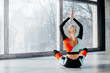 © MZaitsev - young woman practicing yoga in fitness studio