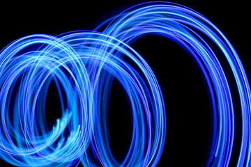 Wall Mural - Blue light painting photography, long exposure, blue streaks of vibrant color against a black background