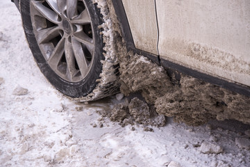 Dirty car tire with snow