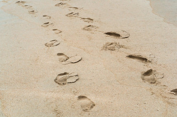 Footprints in the sand. Walking on the sea beach. 