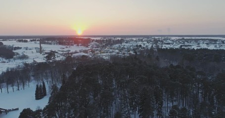 Wall Mural - Aerial view of beautiful sunset at winter forest. Trees covered with snow and frost.