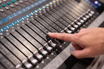 Hand using sound music mixer control panel in the event hall