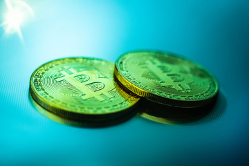 Two bitcoin coins isolated on technological blue background.