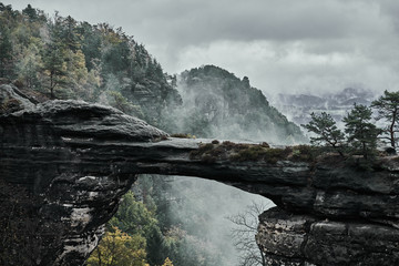misty foggy landscape of the pravcicka gate (pravcicka brana) the largest natural sandstone arch in 