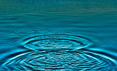 Ripples on sea texture pattern background. Round droplets of water over circles on pool water. Fresh water drop, whirl and splash. Laptop decorative wallpaper. Bright water rings affect the surface.