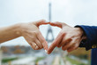 © CRISTINA - A heart formed by a couple near the eiffel tower. The romantic city of Paris, France. Valentine's day