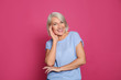 Portrait of mature woman laughing on color background